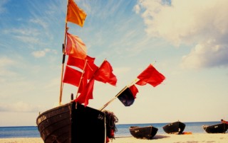 red and white flags on brown wooden boat during daytime